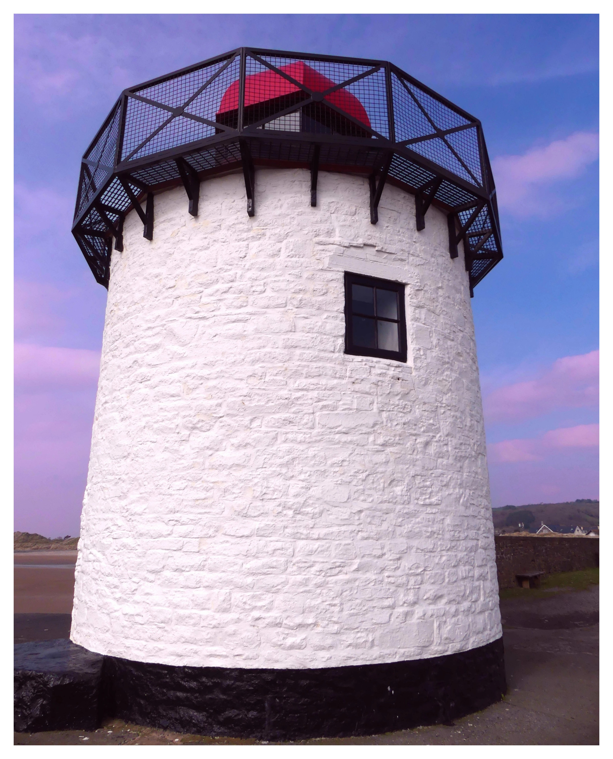 Image of white lighthouse with a red light on top.